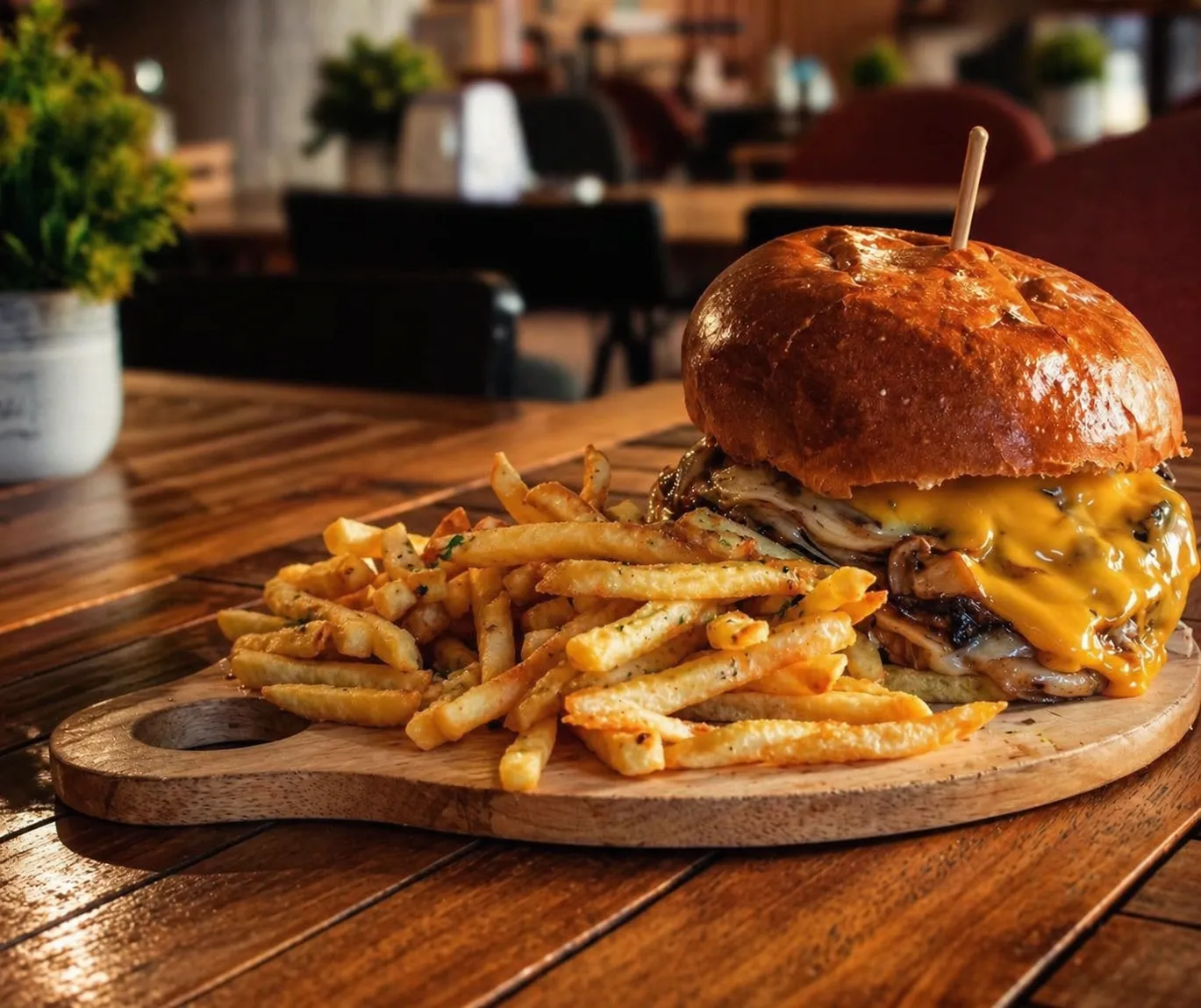 Smash burger with garlic fries on a wooden board